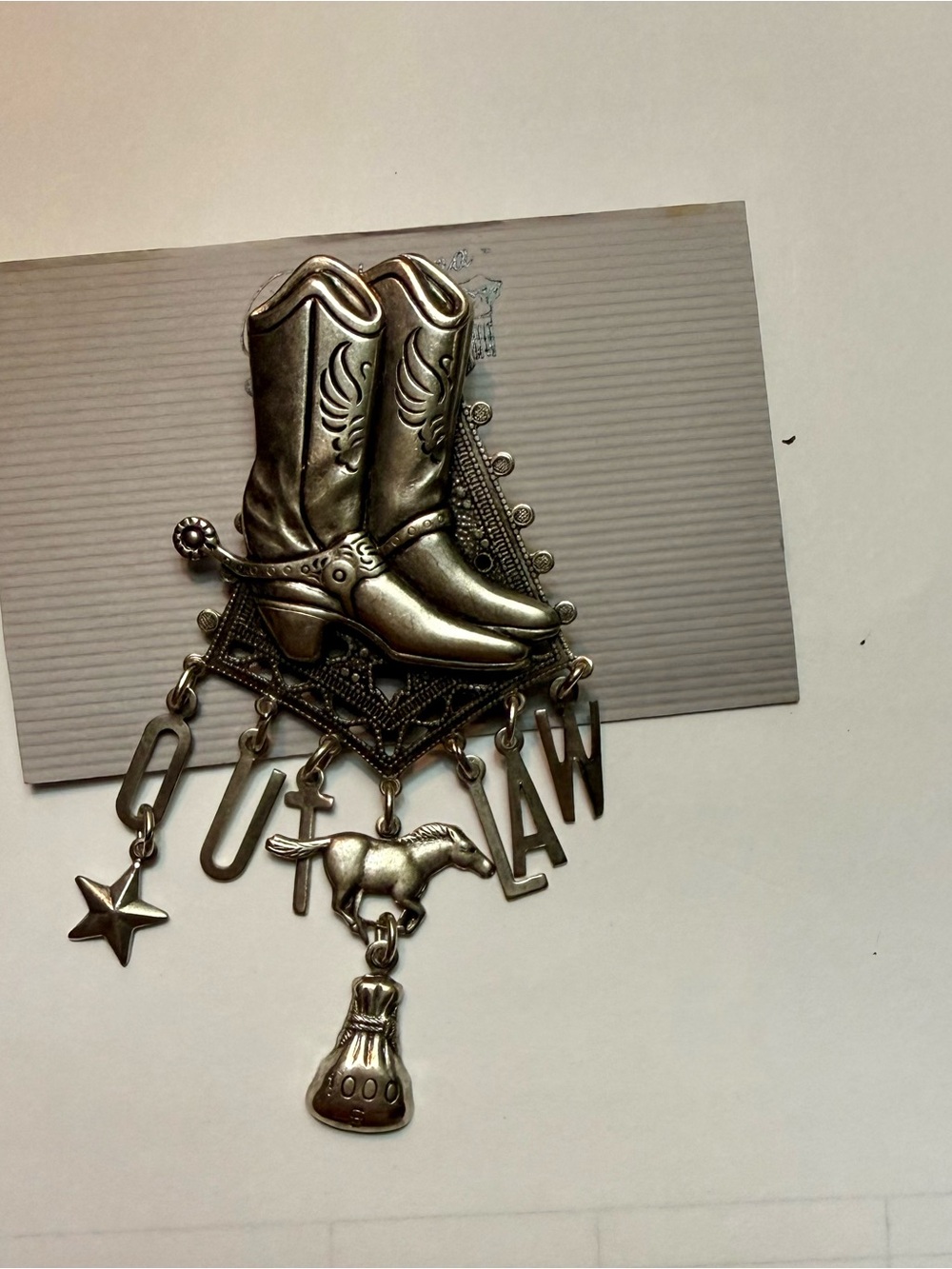 Western brooch spells OUTLAW